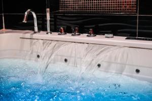 a sink with water coming out of it at Le Cabaret Vip SPA in Lyon