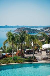 a swimming pool with a view of the water at Hôtel La Villa Douce in Rayol-Canadel-sur-Mer