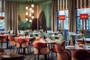 アメルスフォールトにあるVan der Valk Hotel Amersfoort-A1の窓のあるレストラン(テーブル、椅子付)