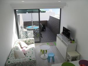 a small living room with a couch and a tv at Sesimbra Bay Apartment in Sesimbra