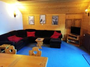 a living room with a black couch and red pillows at Chalet l'Igloo in Pralognan-la-Vanoise