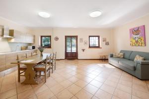 Una cocina y una sala de estar con un sofá y una mesa. en Mono Garden Colombare Teboi, en Lazise
