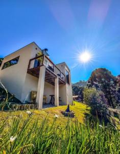 a house on a hill with the sun in the sky at Angatu chalé in Gonçalves
