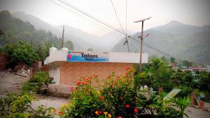 a sign on a building with mountains in the background at Tmboos Homes in Patwa Dunga +11 photos