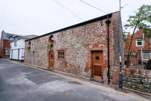 a brick building with wooden doors on a street at The Stables at The Talbot in Lytham St Annes