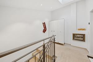 an empty room with a staircase and white walls at Vaicun Stays - LUXURY APARTMENTS - Apartments mit Blick auf den Tegernsee in Gmund am Tegernsee