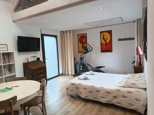 a bedroom with a bed and a table and a television at Maisonnette bois in Longuenesse