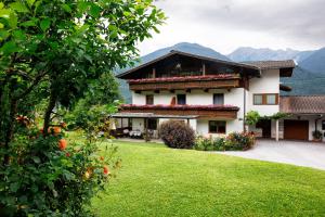 a house with a green yard in front of it at Ferienwohnung Simlhof in Inzing