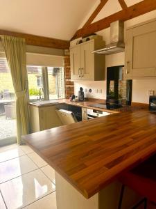 eine Küche mit einer hölzernen Arbeitsplatte in einem Zimmer in der Unterkunft Otters Holt at Tove Valley Cottages in Towcester