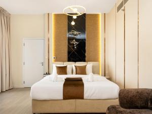 a bedroom with a large white bed and a couch at Dubai Eye & Palm View #JBR Beach # ULTRA Luxurious 2 BHK in Dubai