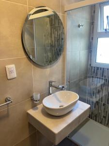 een badkamer met een wastafel en een spiegel bij Apartamento AVITA - Centro in San Miguel de Tucumán