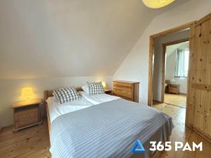 a bedroom with a large bed with two pillows at 365PAM - Urocze Domki Letniskowe blisko morza in Bobolin