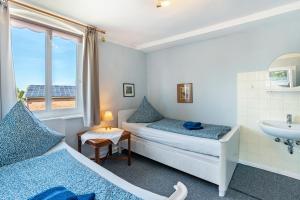 a bedroom with two beds and a sink and a window at Ferienwohnung Bauernhof Rohde in Gremersdorf