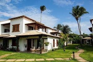ein weißes Haus mit Palmen im Hof in der Unterkunft Casa Cajú in Cruz