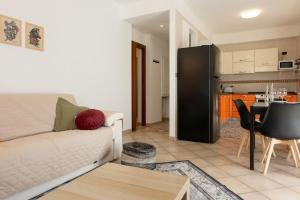a living room with a couch and a kitchen at Casa Peonia in Germignaga