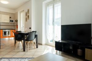 a living room with a table with chairs and a television at Casa Peonia in Germignaga