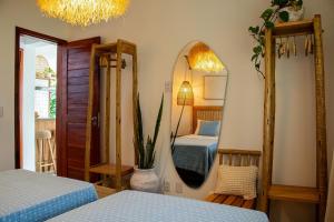 ein Schlafzimmer mit zwei Betten und einem Spiegel in der Unterkunft Casa Cajú in Cruz