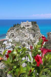 a castle on top of a rocky hill with the ocean at Javelin's Accomodation in Tropea