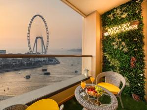 a table with a bowl of fruit and a ferris wheel at Dubai Eye & Palm View #JBR Beach # ULTRA Luxurious 2 BHK in Dubai