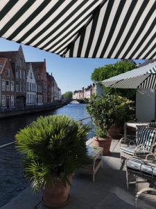 a view of a river from a patio with plants at Hotel Van Cleef in Bruges +37 photos