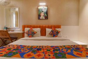 a bedroom with a bed with a colorful comforter at FabHotel Geetraj Palace in Lucknow