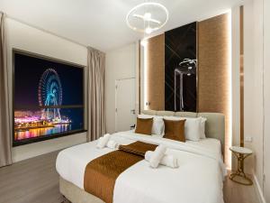 a hotel room with a large bed and a ferris wheel at Dubai Eye & Palm View #JBR Beach # ULTRA Luxurious 2 BHK in Dubai +64 photos