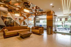 a lobby with a couch and a coffee table in a building at FabHotel Geetraj Palace in Lucknow