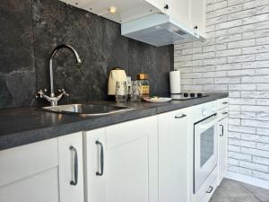 a kitchen with white cabinets and a sink at Apart 36 in Lębork