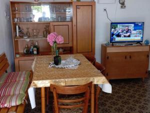 a dining room table with a vase of flowers on it at Rustic house Hutovo Blato in Čapljina