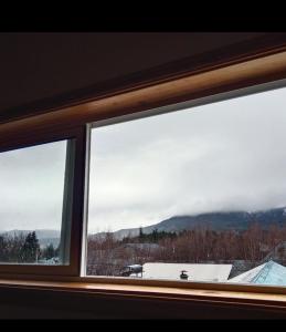 a window with a view of a snow covered mountain at Ruta 7 in Coihaique