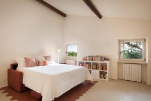 a bedroom with a large white bed and a book shelf at Il Belcanto Villa with Pool in Cavaion Veronese +59 photos