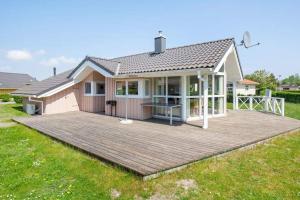 una casa con una gran terraza en un patio en Matrosenhus - Strandpark 40, en Grömitz