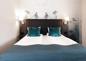a bedroom with a large bed with blue pillows at Bårdshaug Herregård in Orkanger +43 photos