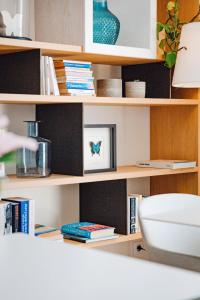 a book shelf with books and a toilet on it at Hôtel La Villa Douce in Rayol-Canadel-sur-Mer