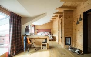 a room with wooden walls and a bed and a window at La Genzianella Bormio in Bormio