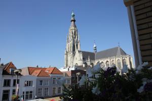 a tall building with a clock tower on top of it at Stadshotel De Klok in Breda