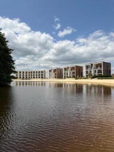 a row of apartment buildings next to a body of water at Luxapartments Studio 303 Penati Golf Resort in Šajdíkove Humence