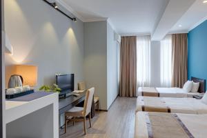 a hotel room with two beds and a desk at Hotel Mevora in Tbilisi City +26 photos