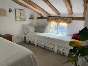 a bedroom with a bed and a window at Casa del Rellotge in Benifallet