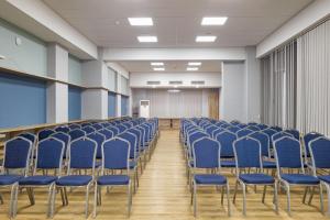 an empty room with blue chairs in a classroom at Hotel Mevora in Tbilisi City