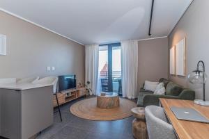 a living room with a couch and a table at Modern One Bedroom Wavescapes Apartment Muizenberg in Muizenberg