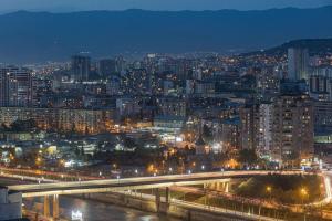 a city skyline at night with a bridge and buildings at Hotel Mevora in Tbilisi City