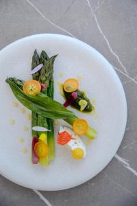 a white plate topped with vegetables on a table at Hôtel La Villa Douce in Rayol-Canadel-sur-Mer