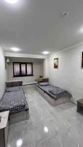 two beds in a large room with at Hostel Art Sergeli in Stantsiya Kyzyl-Tukumachi