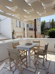 a white table and chairs on a patio at Central Parikia stay-Helios in Parikia +14 photos