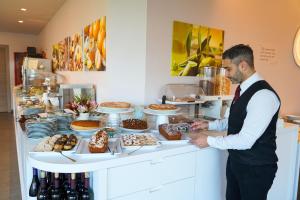 a man standing in front of a table of food at LUZIA AGRIRESORT - Piscina Panoramica e vista Mare a Capo Vaticano in Capo Vaticano +259 photos