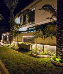 a house with palm trees in a yard at night at The White Suites in Karachi