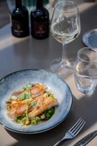 a plate of food on a table with wine glasses at Hôtel La Villa Douce in Rayol-Canadel-sur-Mer