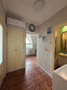 a room with a clock on the wall and a bathroom at Garsonieră lângă Prefectură in Craiova