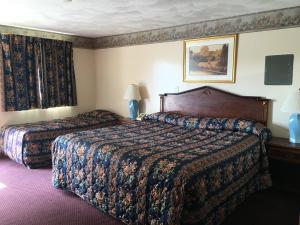 um quarto de hotel com duas camas e uma janela em Knotty Pine Motel em Salisbury